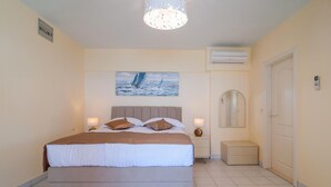 A bedroom with a bed, a nightstand, a bedside lamp, a painting, an air conditioning unit, a mirror, and a door. - Awesome apartment in Okrug Donji (Okrug Donji)