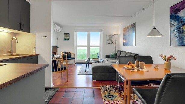 Une cuisine moderne avec un coin repas, un canapé et une vue sur l’extérieur.