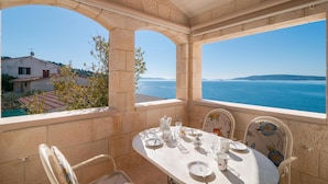 Comedor con una mesa dispuesta para dos personas, con vistas a la costa.
