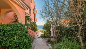 A narrow pathway leading to a building with a view of the sea. - Cozy apartment in Njivice with WiFi (Njivice)