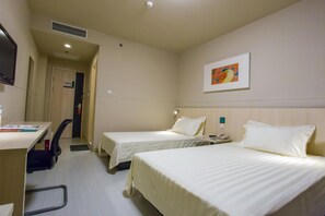 A hotel room with two beds, a desk, a chair, a telephone, and a painting on the wall. - Jinjiang Inn (Tianjin South Railway Station) (Tianjin)
