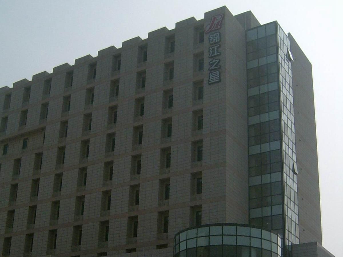 Un edificio de varios pisos con un letrero vertical llamativo a la derecha.