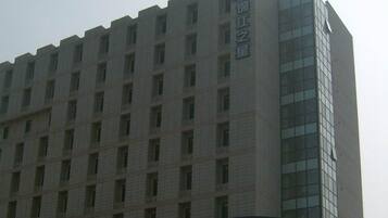 A multi-story building with a prominent vertical sign on the right side.