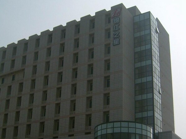 A multi-story building with a prominent vertical sign on the right side.