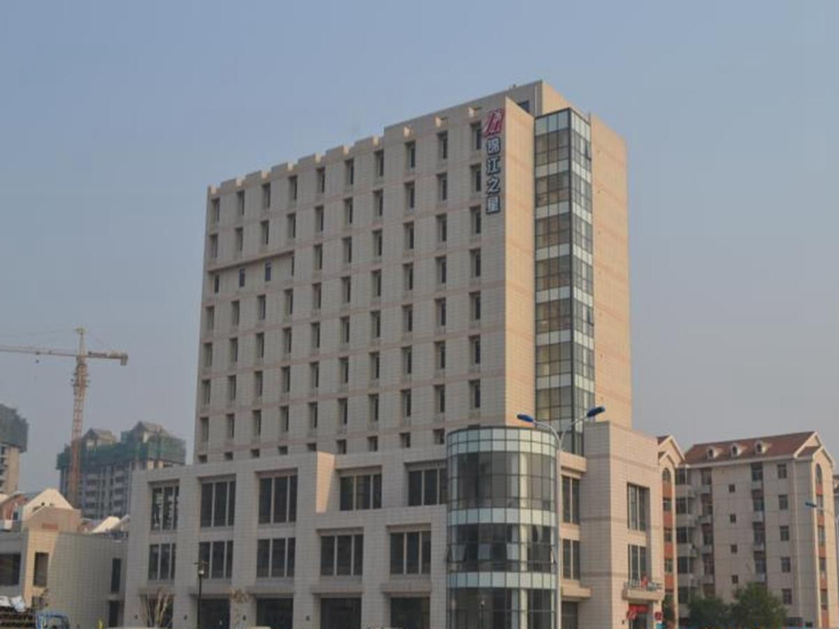 A multi-story hotel with a prominent glass facade and a central cylindrical structure.