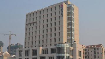 Hotel com vários andares, fachada de vidro destacada e estrutura cilíndrica central.