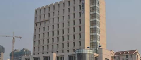 A multi-story hotel with a prominent glass facade and a central cylindrical structure.