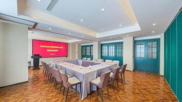 A conference room with a large table, chairs, a podium, and a screen.
