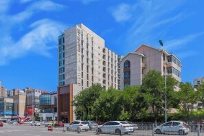 Un edificio moderno con varios pisos, amplias ventanas y fachadas de vidrio y concreto.