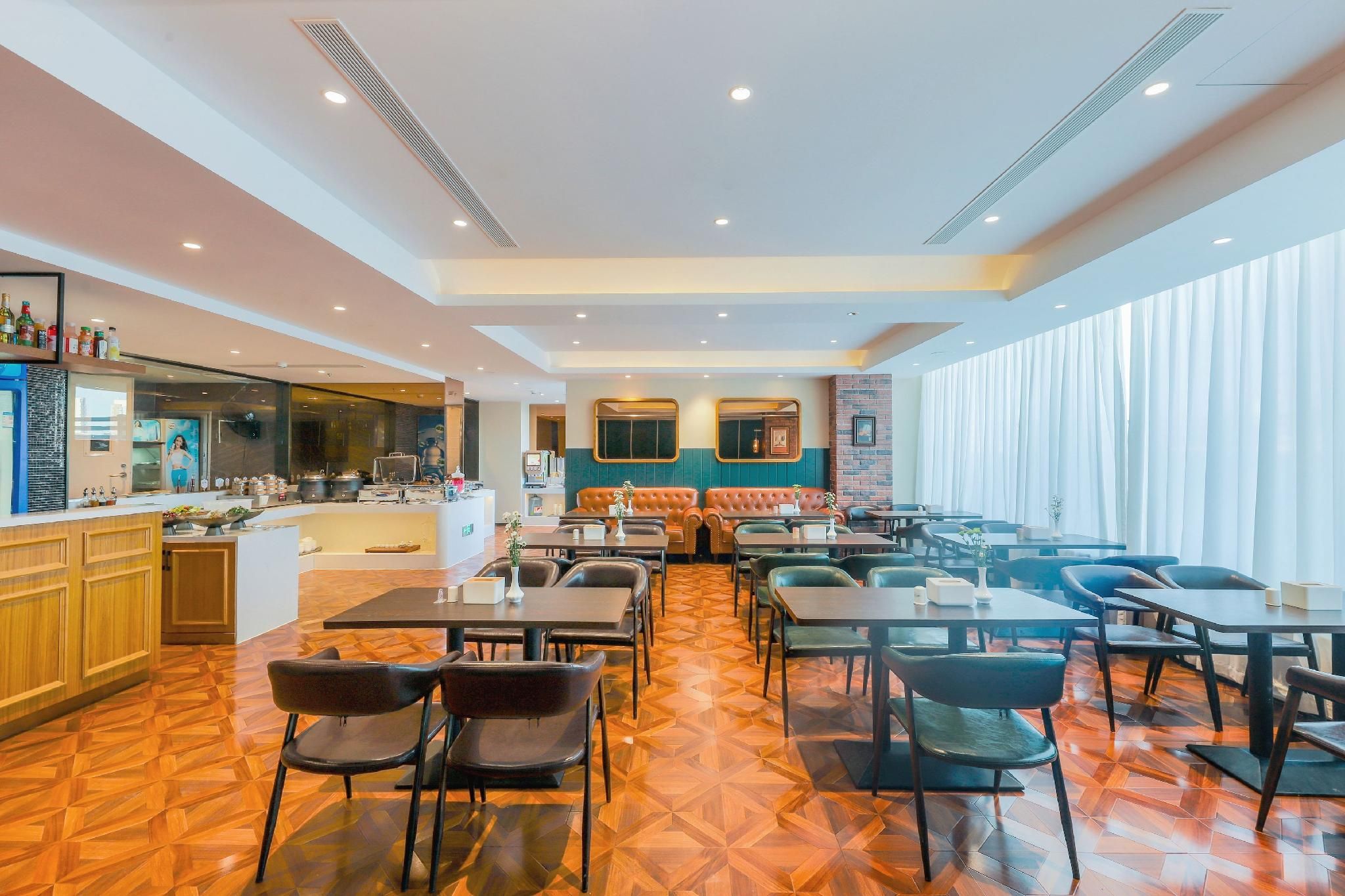 A hotel lobby with a bar area, seating arrangements, and a patterned floor.
