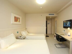 A hotel room with two beds, a desk, a television, and a door leading to another room. - Jinjiang Inn (Tianjin South Railway Station) (Tianjin)