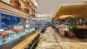 Un interior de restaurante moderno con un mostrador de mariscos, una zona de mesas y un cocinero preparando comida.