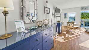 A room with a blue dresser, a lamp, a large mirror, and a view of the beach. - "Golden on 30A" | Gulf Views | Pool & hot tub | Tennis | Walk to Shops & Restaurants (Santa Rosa Beach)