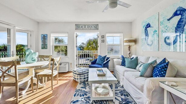 A spacious living room with a dining area, a ceiling fan, and a sign reading "BEACH HOUSE". - "Golden on 30A" | Gulf Views | Pool & hot tub | Tennis | Walk to Shops & Restaurants (Santa Rosa Beach)