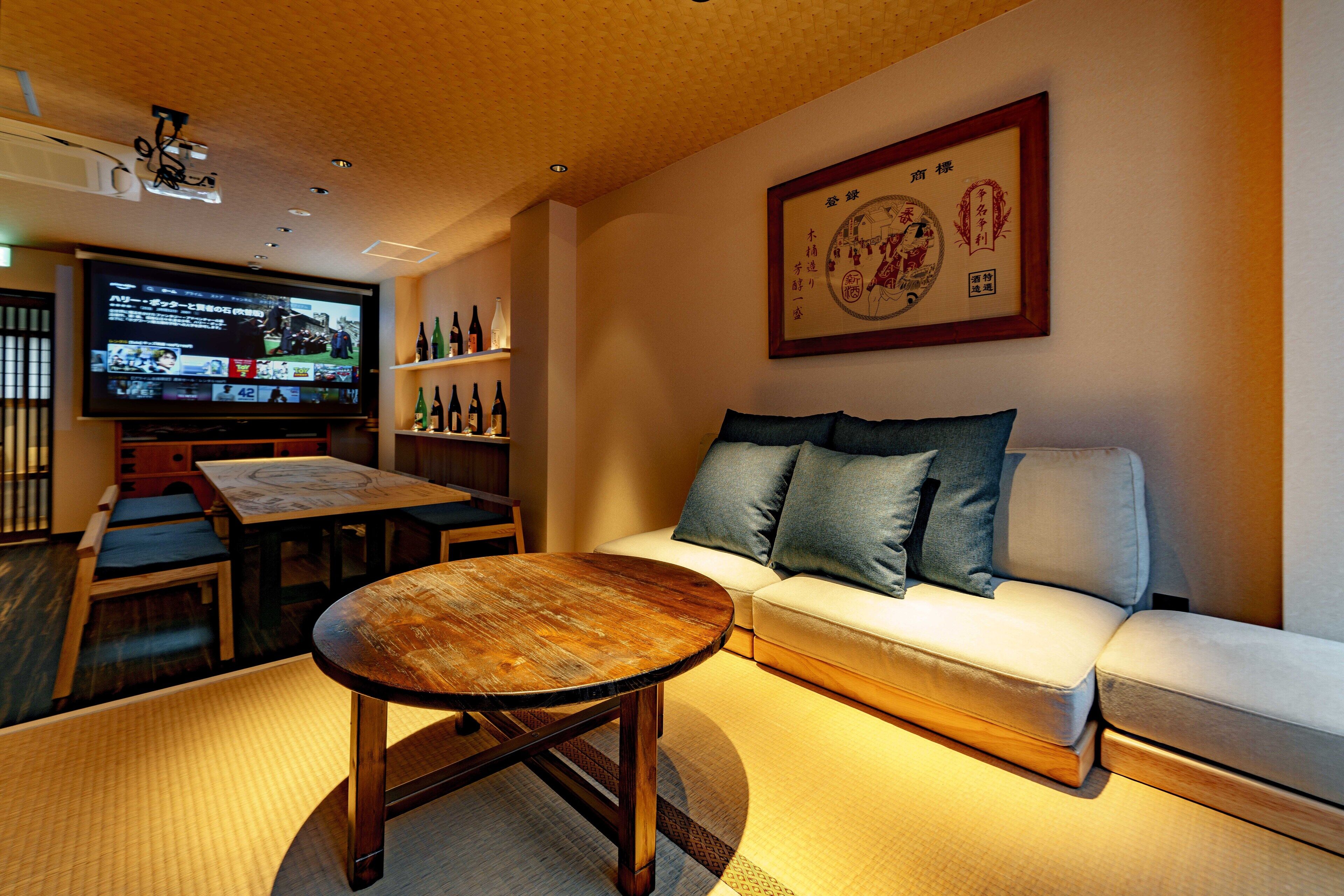 A living room with a sofa, a coffee table, a television, and a wall-mounted picture frame.