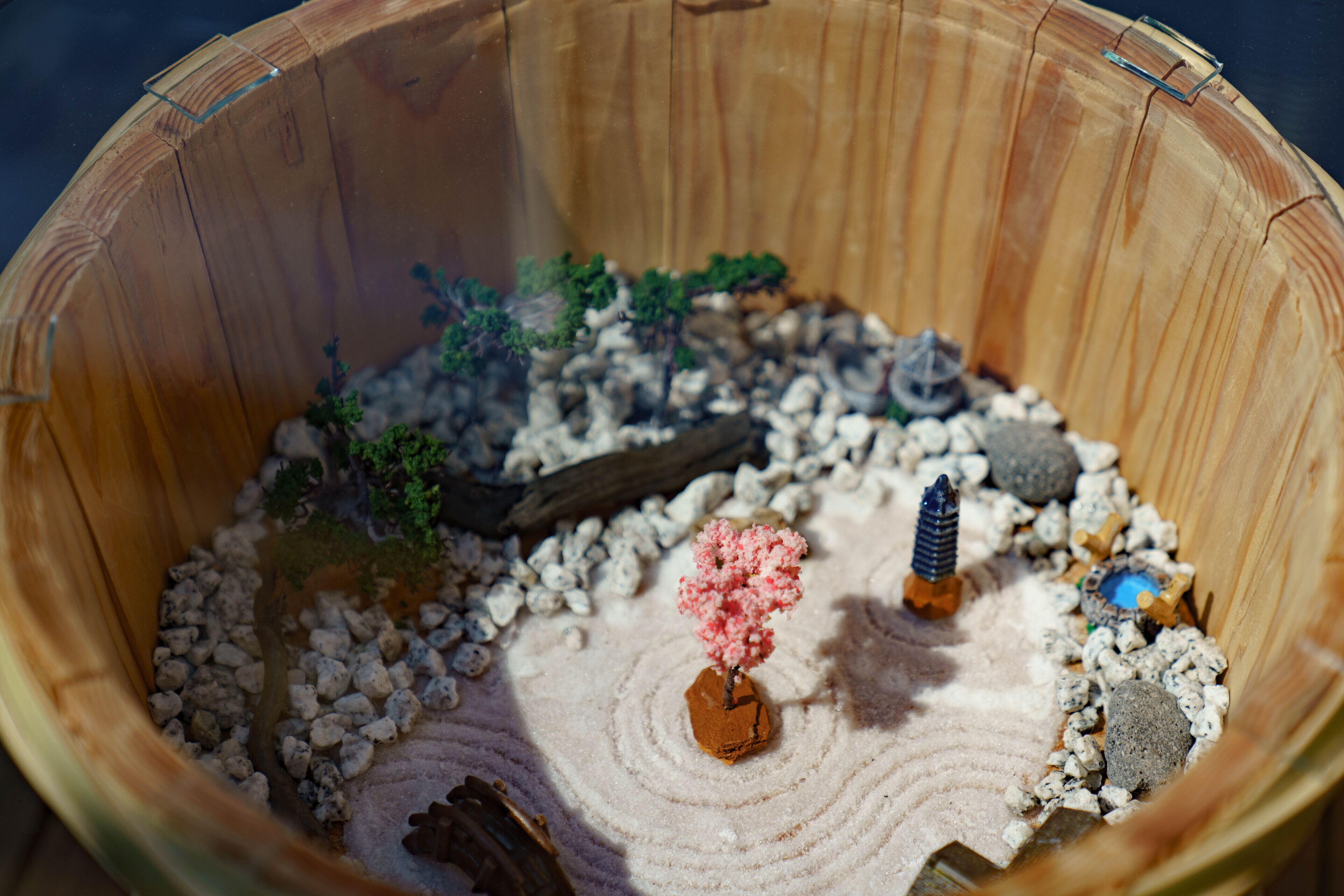 A miniature landscape model with a small tree, rocks, and a log.