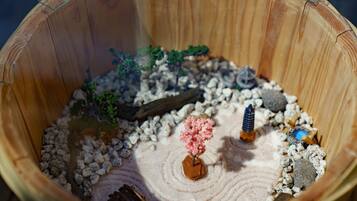 A miniature landscape model with a small tree, rocks, and a log.