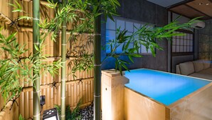 A room with a bamboo wall, a blue pool, and a seating area. - KONJAKUSO Osaka Bentencho "HIKARIYUYA" Projection Mapping SPA (Osaka)