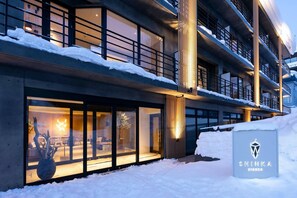 A modern building with large windows and a snow-covered ground. - Shinka Niseko (Kutchan)