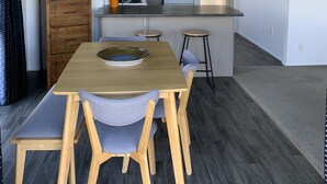 Una cocina moderna con una isla central, una mesa de comedor de madera y sillas.