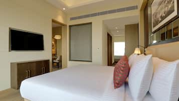 A hotel room with a large bed, a flat-screen TV, a wooden cabinet, and a framed picture on the wall.