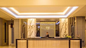 Un'area reception dal design moderno, con una scrivania, una parete decorata e un soffitto con illuminazione a incasso.