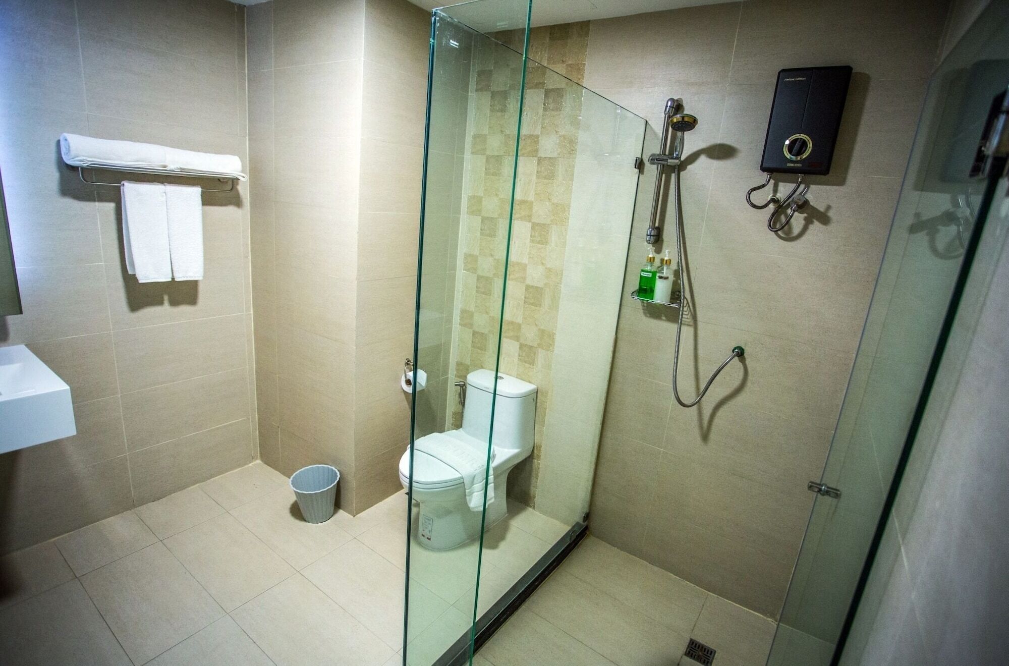 A glass-enclosed shower stall with a toilet and a towel rack.