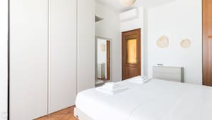 A bedroom with a bed, a dresser, a mirror, and a door. - Italianway - Il Borgo apartments (Finale Ligure)