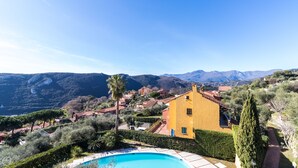 A hillside villa with a swimming pool, surrounded by lush greenery and mountains in the background. - Italianway - Il Borgo apartments (Finale Ligure)