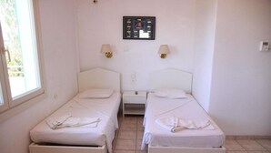 A room with two single beds, a small bedside table, a wall-mounted picture frame, and two wall-mounted lamps. - Mary Anna Villa (Hersonissos)