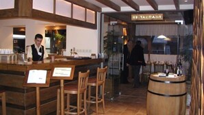 A restaurant interior with wooden bar stools, a bar counter, and a wooden barrel. - Razlog Hotel (Razlog)