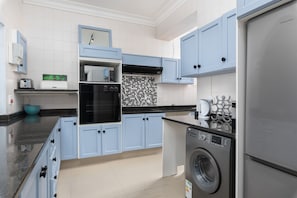 Apartamento Signature | Cocina privada | Frigorífico grande, microondas, horno y placa de cocina