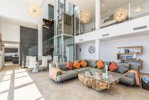 A spacious living area with a sectional sofa, a glass coffee table, and a modern chandelier. - Beautifully located luxury private villa with heated pool and jacuzzi (Salobreña)