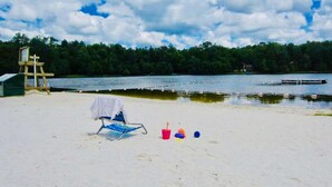 A beach with a wooden structure, a beach chair, and beach toys. - ⛷️⛱️⛰️Family Lake Home❤️3BR★HotTub★Fireplace★Games★Boat/Fish★Dogs+ (Pocono Lake)