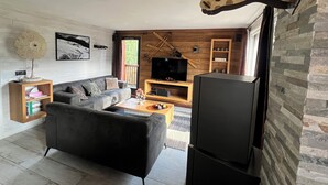 Un salon moderne avec un canapé, un téléviseur et des éléments décoratifs en bois.