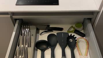 Un cajón de cocina con utensilios, como una espátula, una cuchara grande y un batidor.