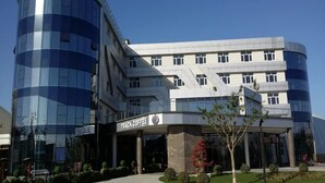 A modern building with a curved glass facade and a sign for 'TRACK COFFEE'.