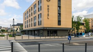 Een modern hotelgebouw met een opvallend “HOTEL” bord op de gevel.