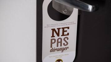 A door sign with the text "NE PAS déranger" and a logo.