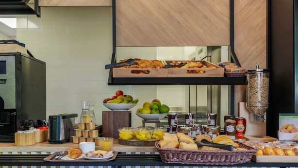 Een ontbijtbuffet met diverse gerechten, zoals fruit, gebak en drankjes.
