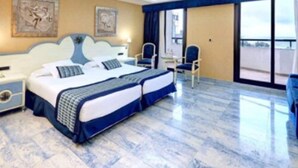 Habitación de hotel con dos camas, un escritorio y una silla.