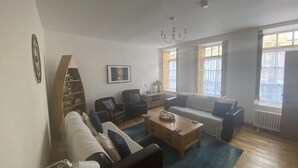 A living room with a sofa, chairs, a coffee table, and a chandelier. - Coastal 2-bed Cottage for 4 Cellardyke, Anstruther (Anstruther)