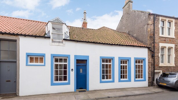 A white building with blue trim and a blue door, featuring a tiled roof and a chimney. - Coastal 2-bed Cottage for 4 Cellardyke, Anstruther (Anstruther)