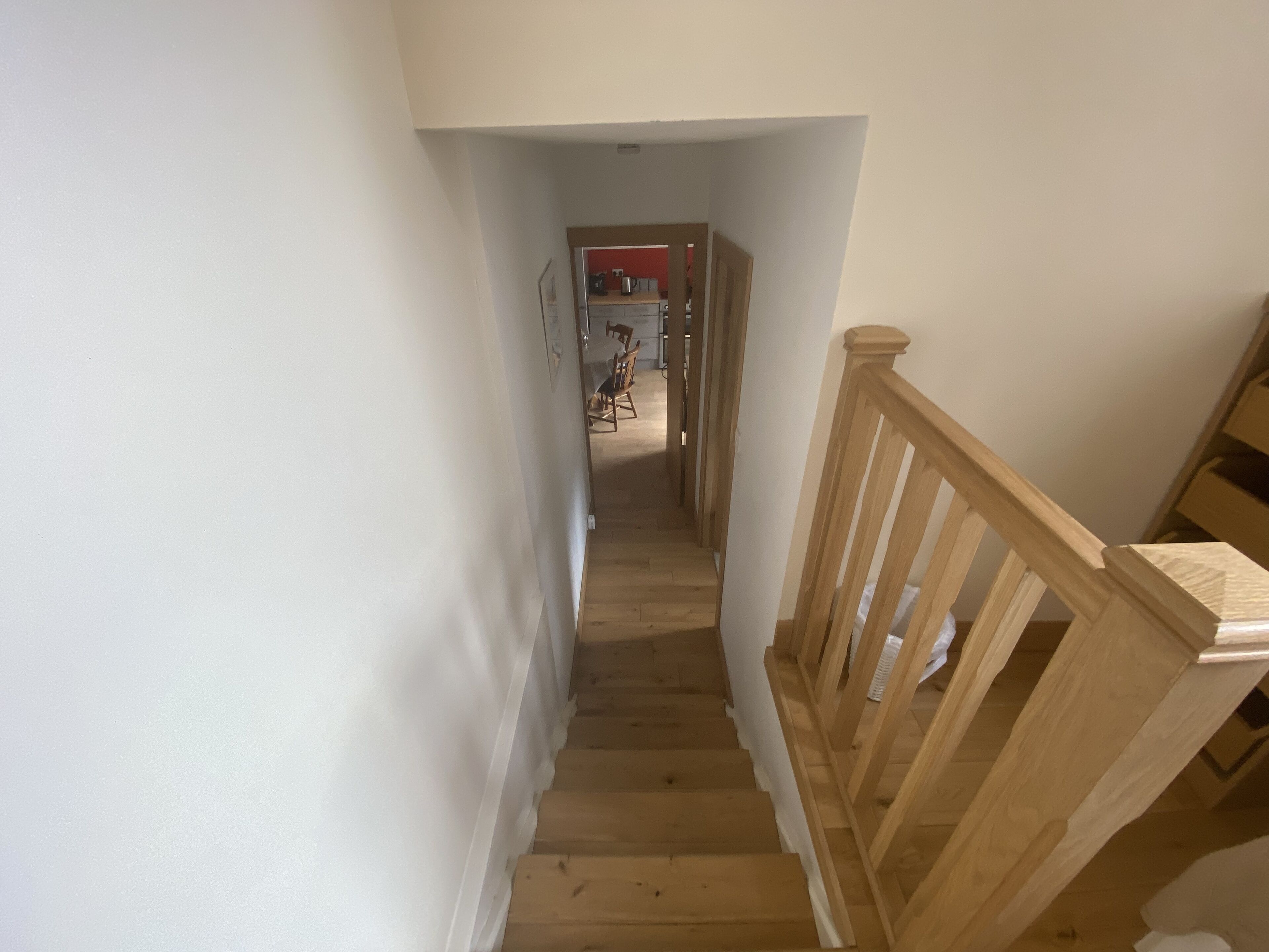 A wooden staircase with a handrail leading to a landing.