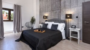 A modern bedroom with a large bed, two bedside tables, a wall-mounted light fixture, and a view through a window. - Villa Trabakul ZadarVillas (Ražanac)