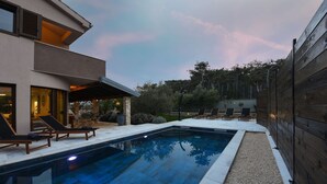A modern house with a swimming pool, outdoor seating, and a wooden fence. - Villa Trabakul ZadarVillas (Ražanac)