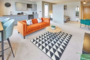 A modern living room with a sofa, a coffee table, and a geometric rug.