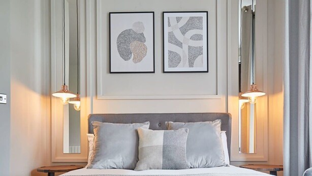 A neatly arranged hotel room with a bed, two bedside tables, and two wall-mounted lamps. - Host & Stay | Skipper's Rest @ North Marine House (Scarborough)