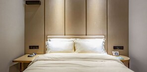 A hotel room with a bed, two bedside tables, and a wall-mounted control panel. - Starway Hotel (Shunyi)