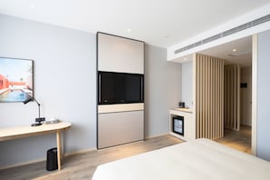 A modern hotel room with a bed, a desk with a computer, a TV, and a small kitchenette. - Starway Hotel (Shunyi)